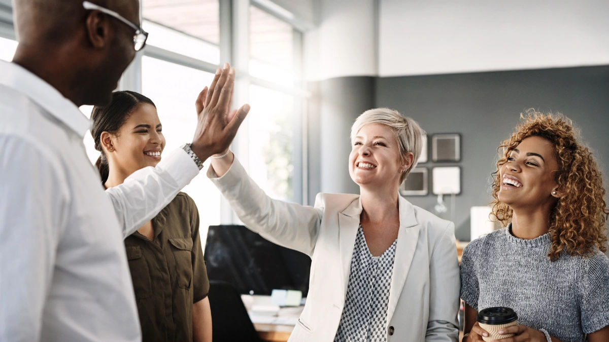 Team high-fiving in office setting